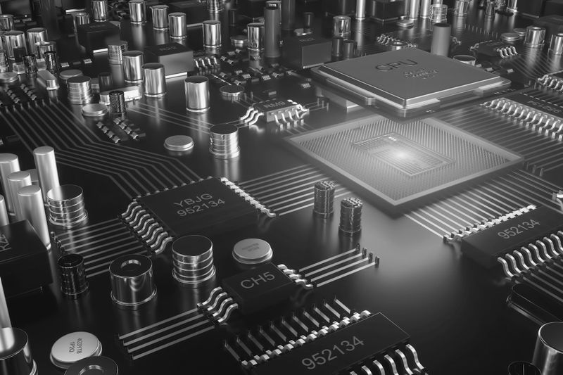 Un primer plano detallado de una placa de circuito electrónico monocroma con chips, capacitores y varios componentes.