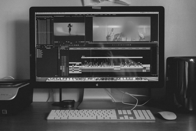 foto en blanco y negro de un monitor en el escritorio, en la pantalla un programa de edición de video