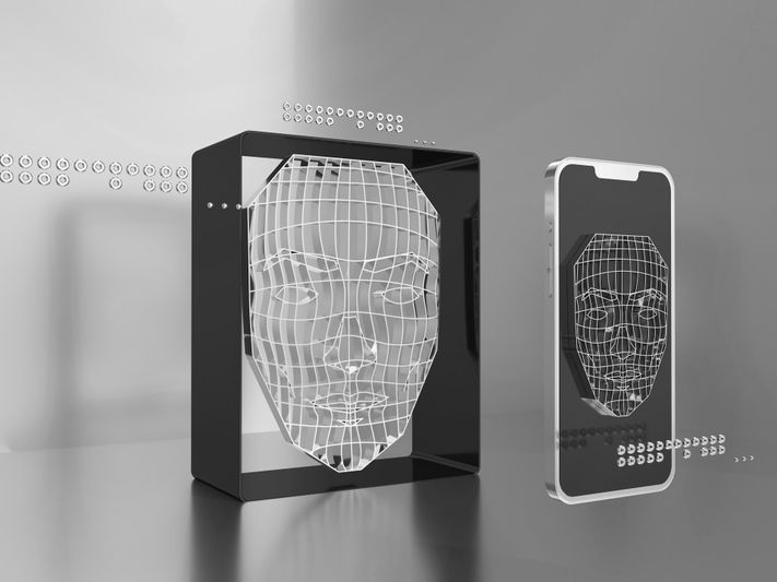 A 3D wireframe face is displayed on a black box and a smartphone, set against a gray background with digital elements.