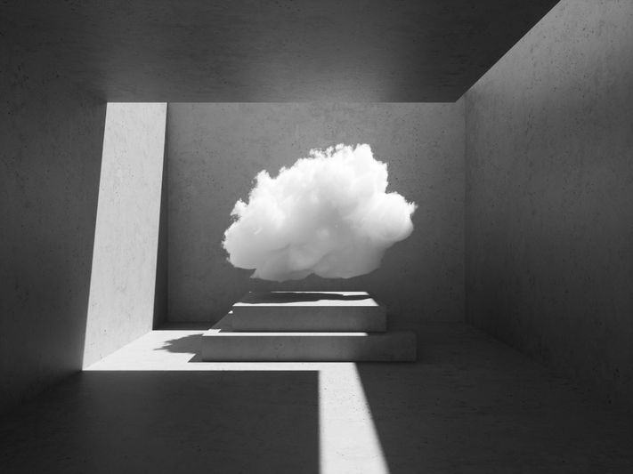 Un nuage blanc et moelleux flotte à l'intérieur d'une pièce minimaliste en béton avec des escaliers, projetant des ombres dans la lumière du soleil qui traverse une ouverture.