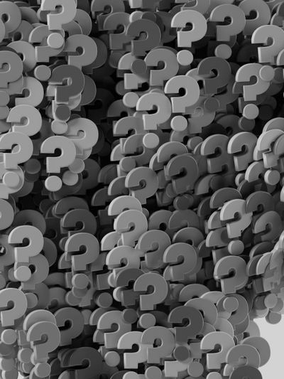 Un groupe dense de points d'interrogation gris tridimensionnels qui se chevauchent, créant un motif texturé et abstrait.