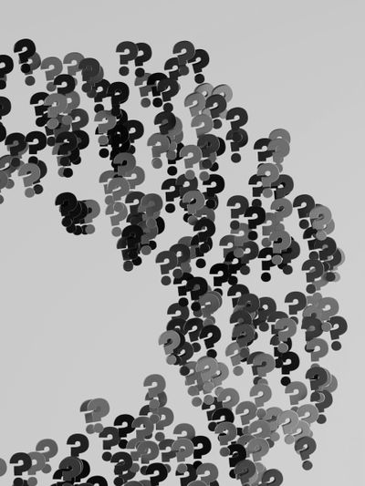 A swirl of black and gray question marks on a light gray background, creating an abstract, dynamic pattern.