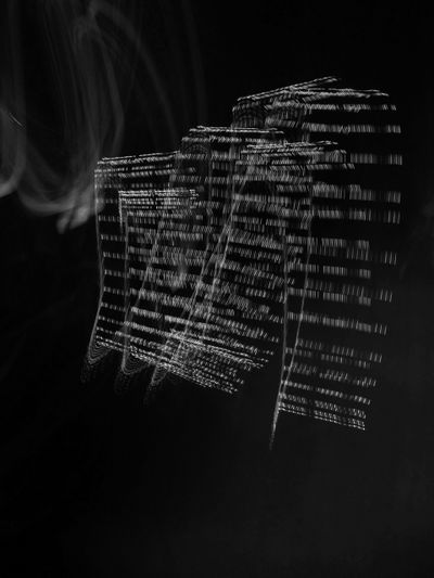 Des traînées lumineuses abstraites formant des formes rectangulaires superposées sur un fond sombre, créant une sensation de mouvement et de profondeur.