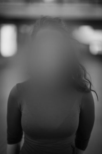 Rostro de mujer con cabello oscuro anonimizado y difuminado, foto en blanco y negro