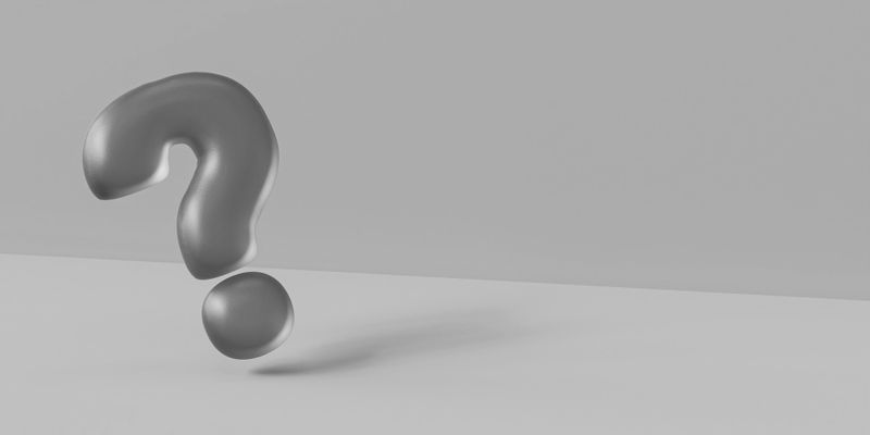 Point d'interrogation métallique 3D sur un fond gris minimaliste, projetant une ombre subtile sur la surface.