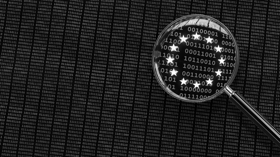 Una lupa resalta el código binario dispuesto en forma de estrellas de la bandera de la Unión Europea sobre un fondo negro lleno de texto binario.