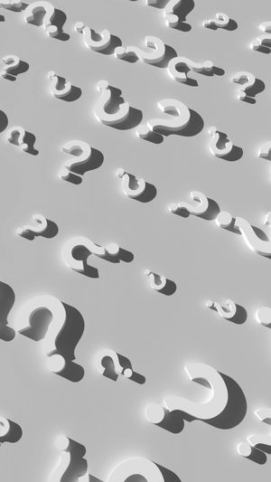 Powtarzające się trójwymiarowe białe znaki zapytania rozrzucone na szarej powierzchni, rzucające miękkie cienie.