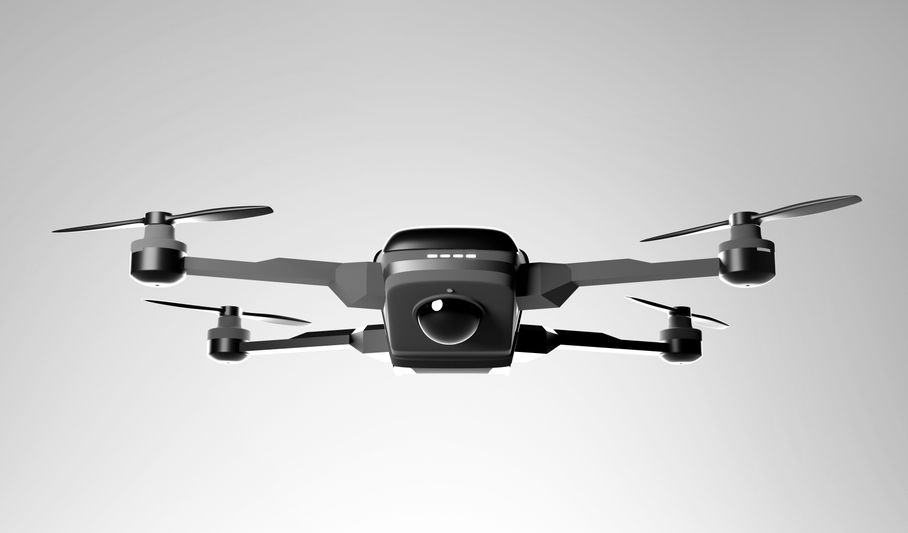 A black quadcopter drone with a camera hovers against a gray background, showcasing its front view and extended rotors.