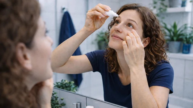 Frau benutzt Augentropfen