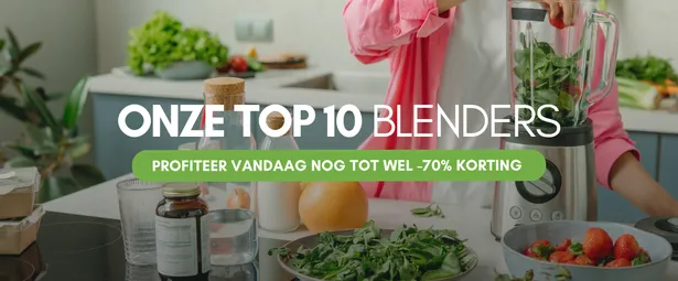 Person in pink jacket making a green smoothie in a blender, surrounded by fruits and vegetables on a kitchen counter.