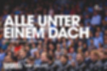 Die deutsche Handballnationalmannschaft steht erhobenen Hauptes in Reihe und Glied. Im Hintergrund ist verschwommen die lückenlos mit Fans besetze Tribüne zu erkennen. Große Headline: Alle unter einem Dach. Darunter: #handballkommtnachhause