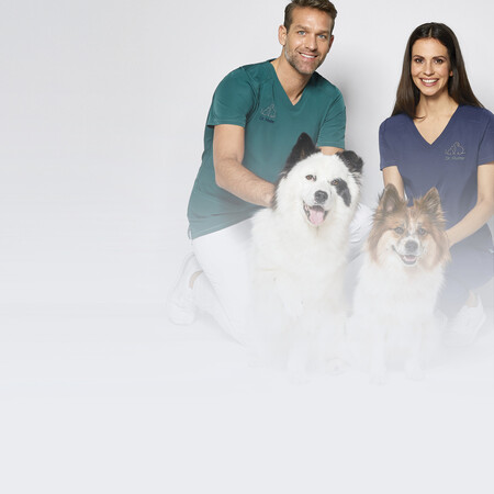 Zwei Personen in 7days Arbeitsbekleidung knien neben zwei kleinen Hunden