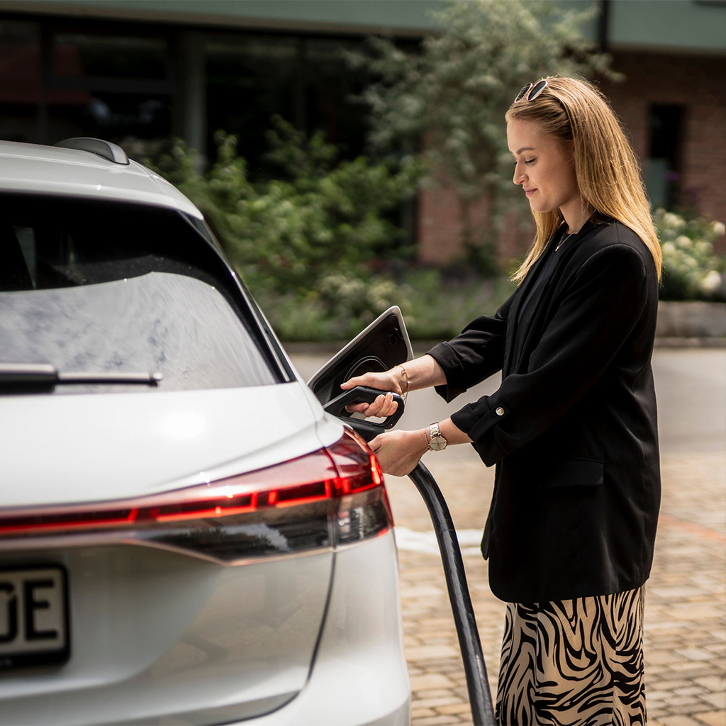 Frau laedt E-Auto