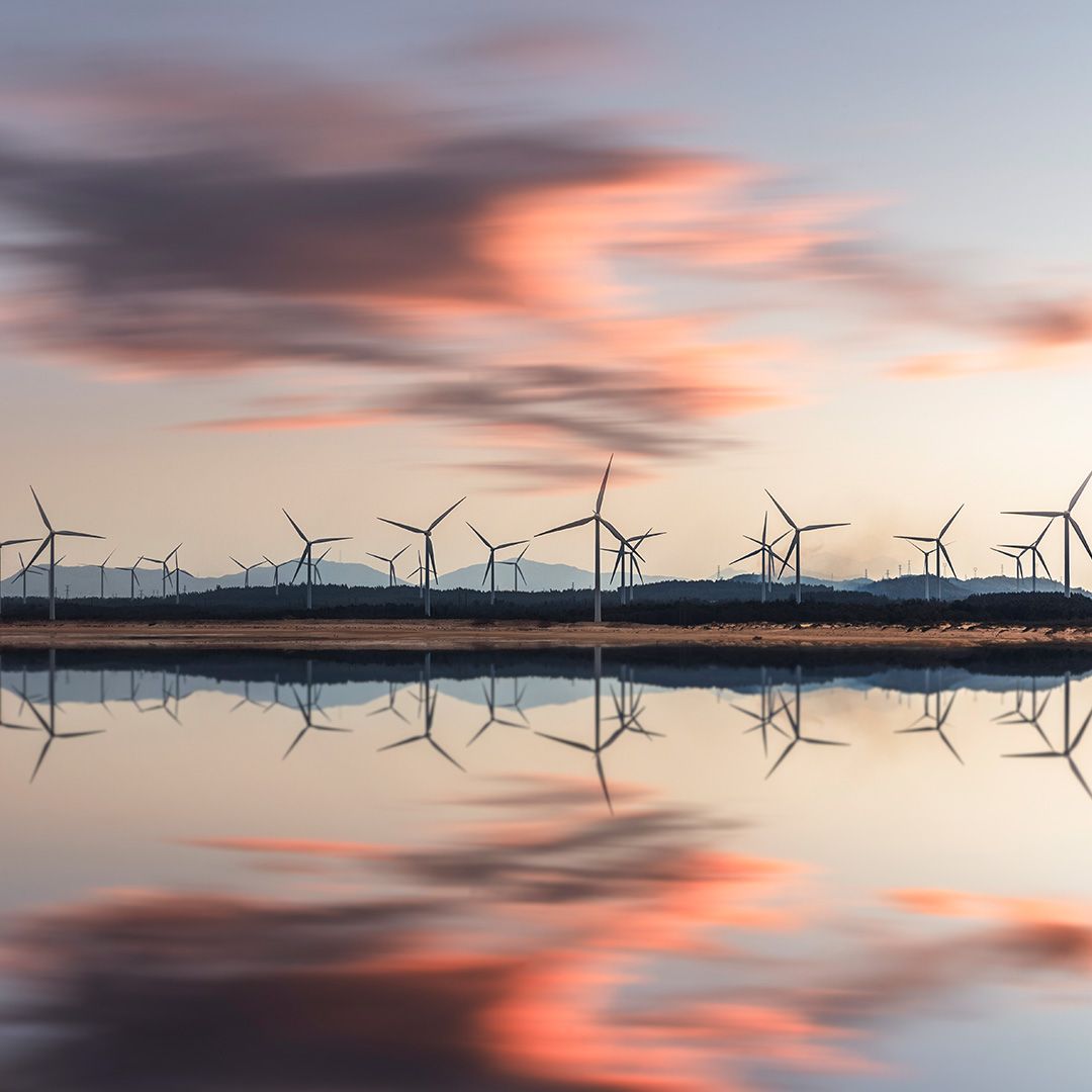 Windraeder spiegeln sich im see bei sonnenuntergang