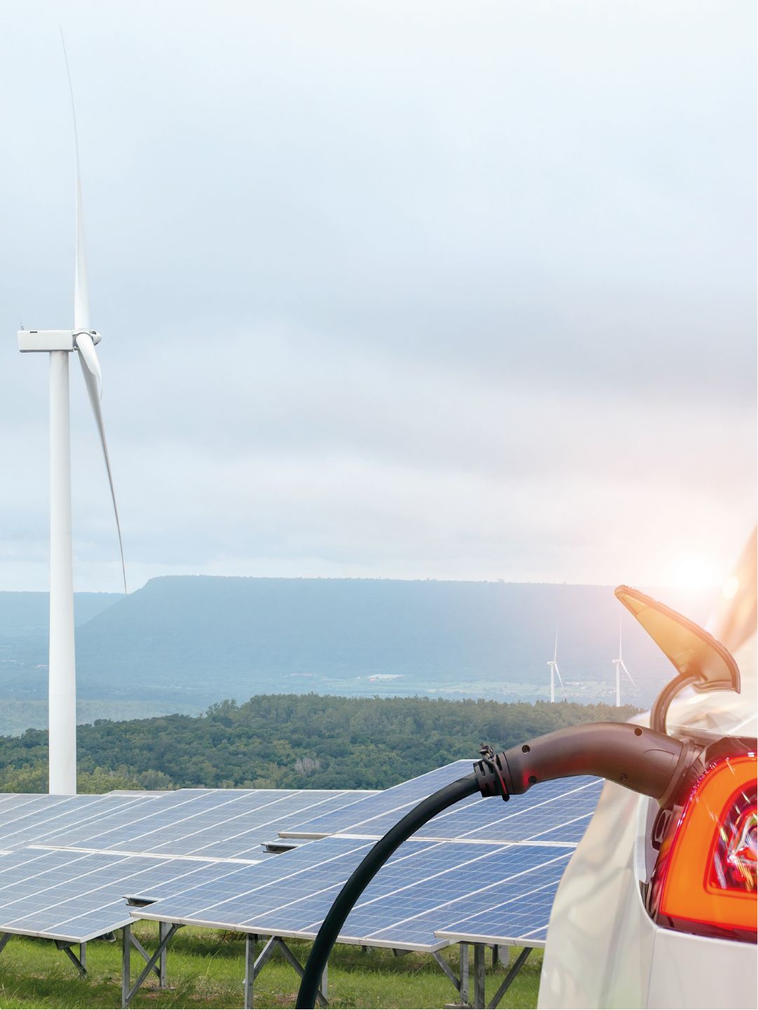 Winräder und eine Solarparkanlage mit einem angesteckten E-Auto