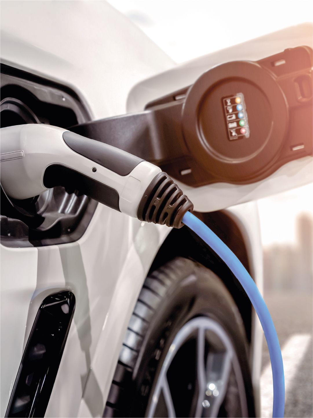 E-Auto lädt vor einer Stadt Skyline
