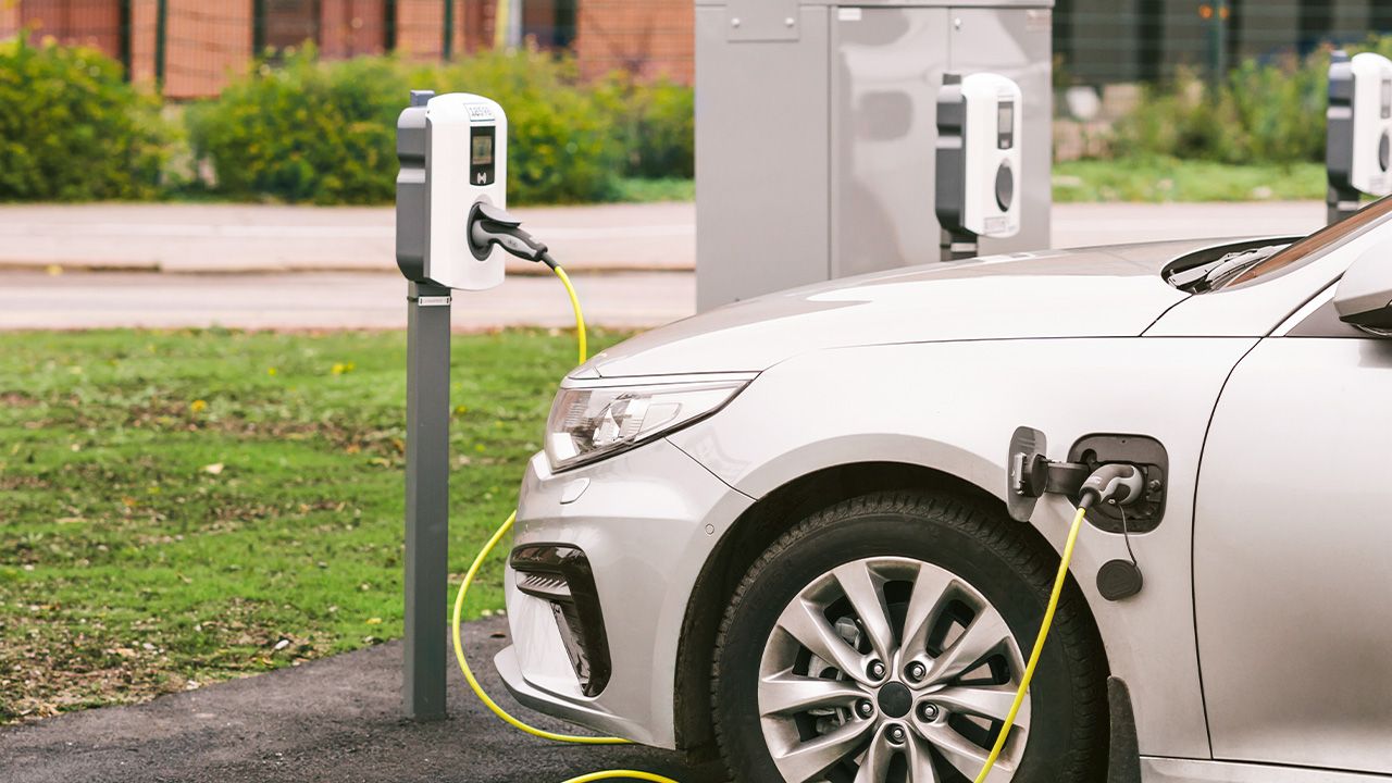 E-Auto lädt an Ladestation auf Parkplatz