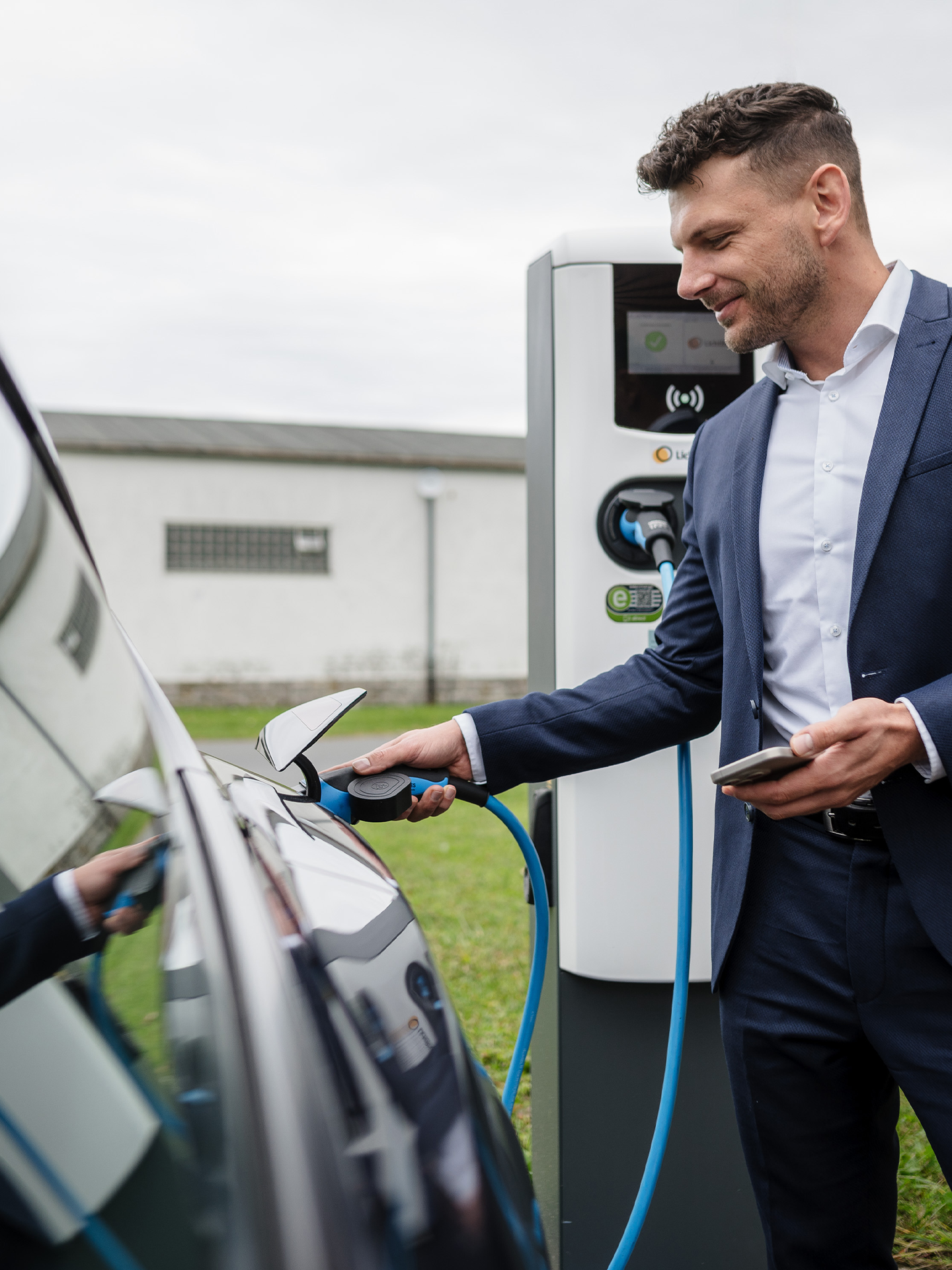 Mann laedt E-Auto an einer Ladestation von LichtBlick