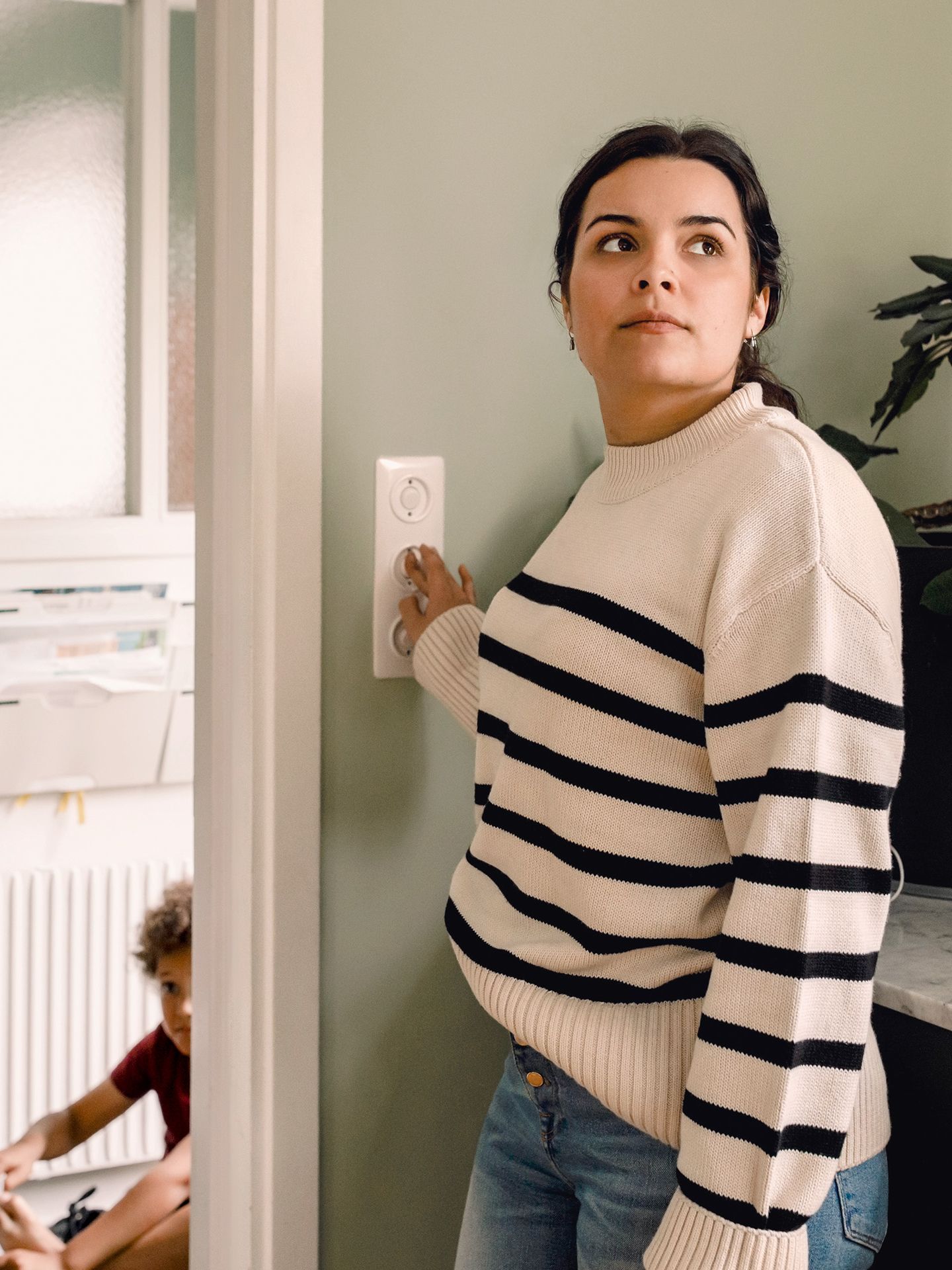 Eine Frau betätigt zu Hause den Lichtschalter