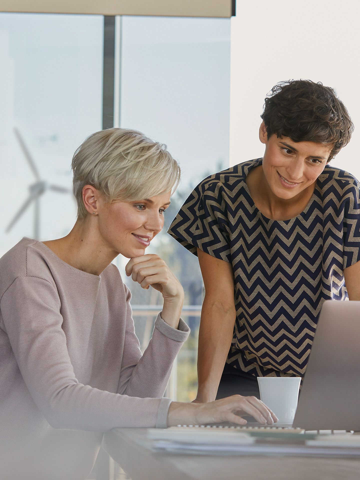 Zwei Frauen schauen auf einen Laptop
