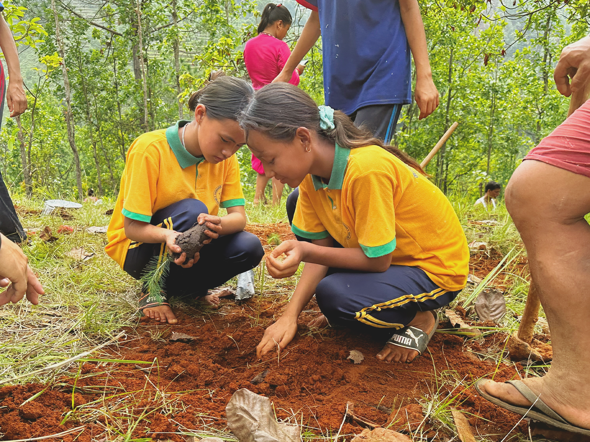 Zwei Maedchen aus Nepal graben in der Erde