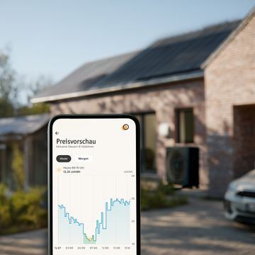 Frau am Handy vor einem Haus mit PV-Anlage