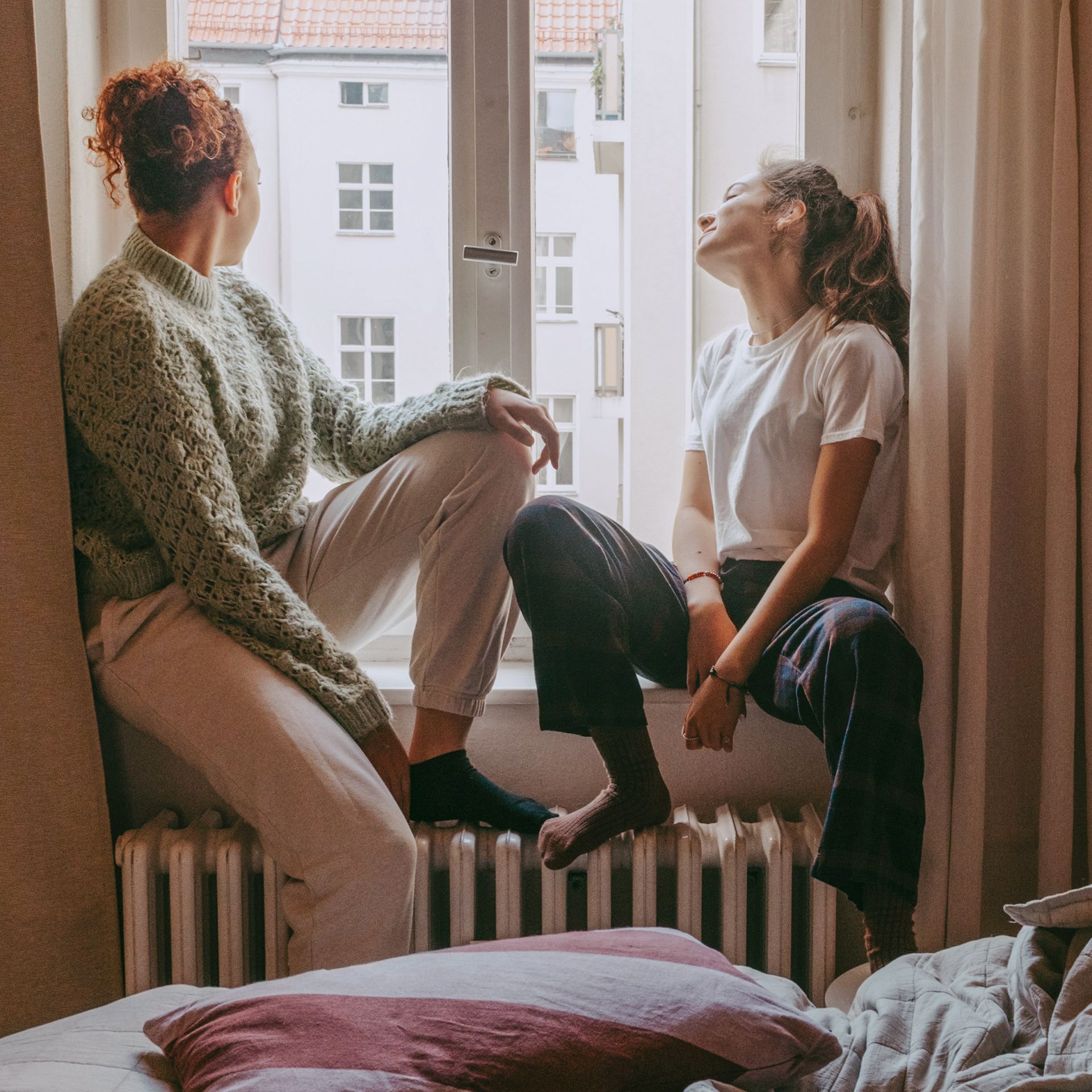 Zwei Frauen sitzen auf Fensterbank