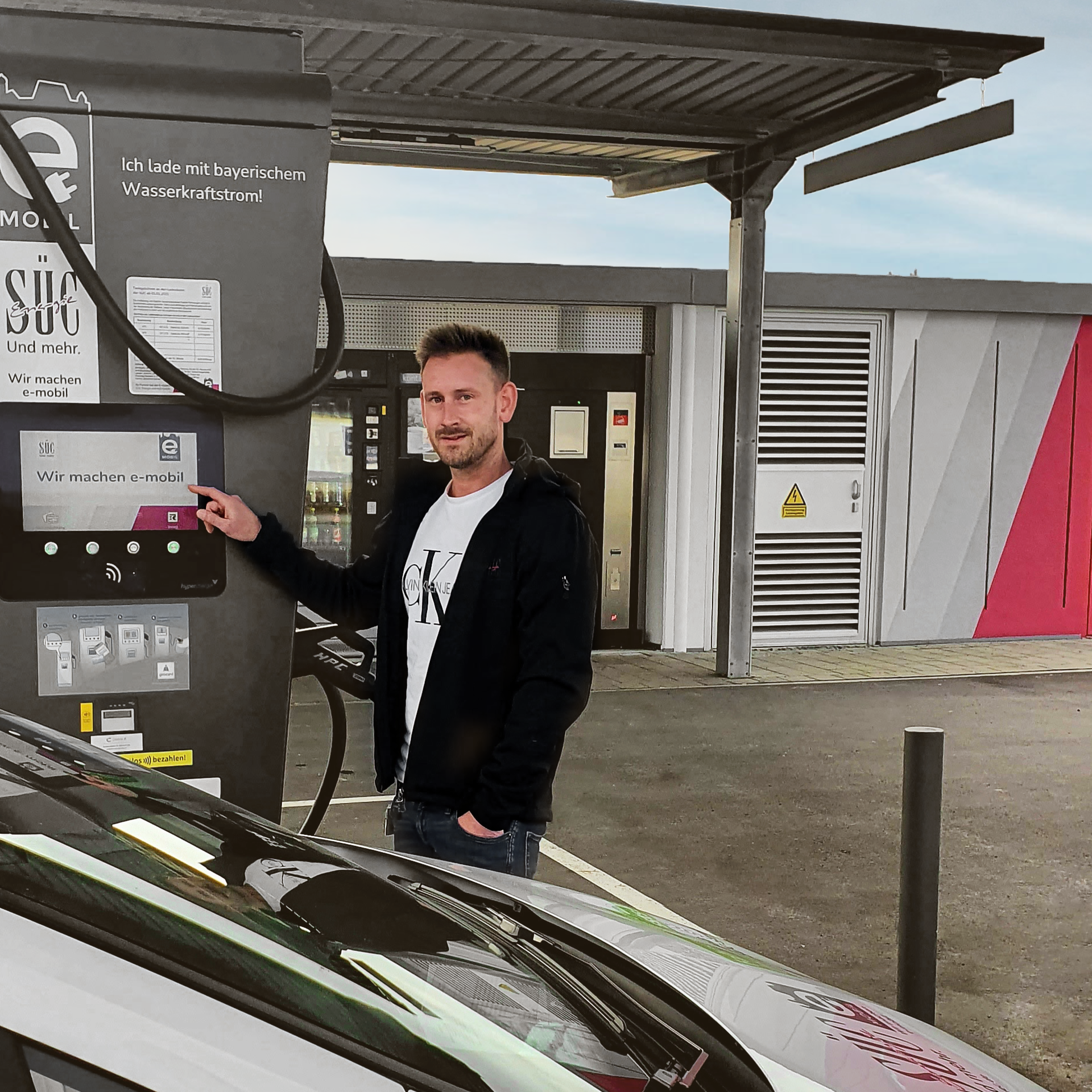 Mann vor E-Ladesaeule