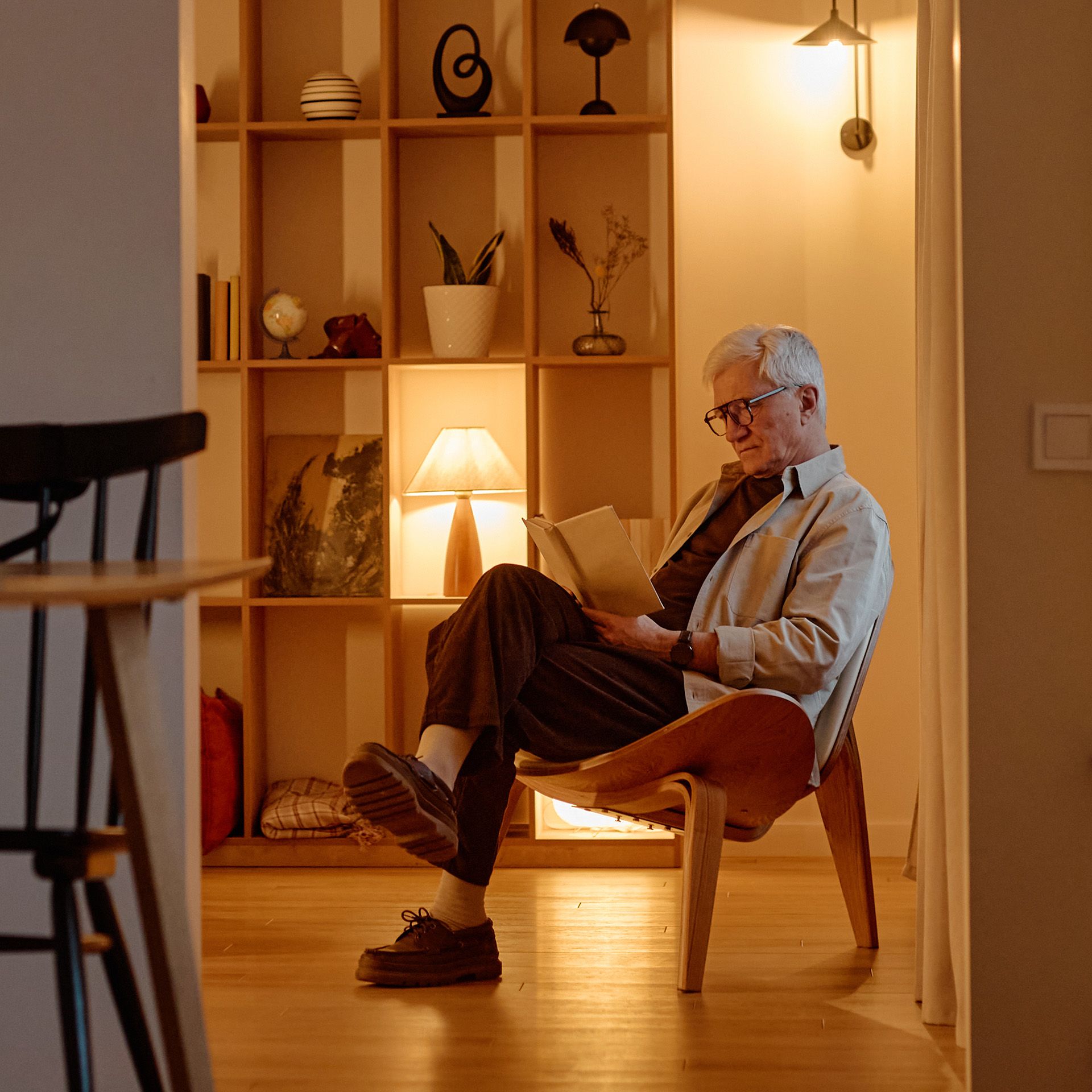 Mann sitzt in Stuhl und liest ein Buch