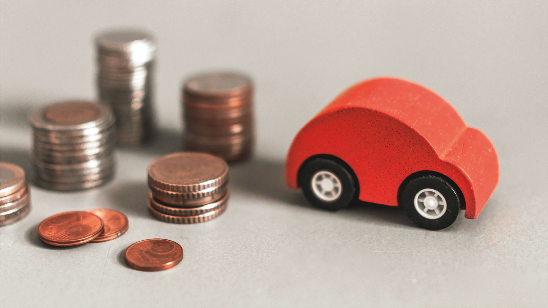 rotes Spielzeugauto mit Münzgeld