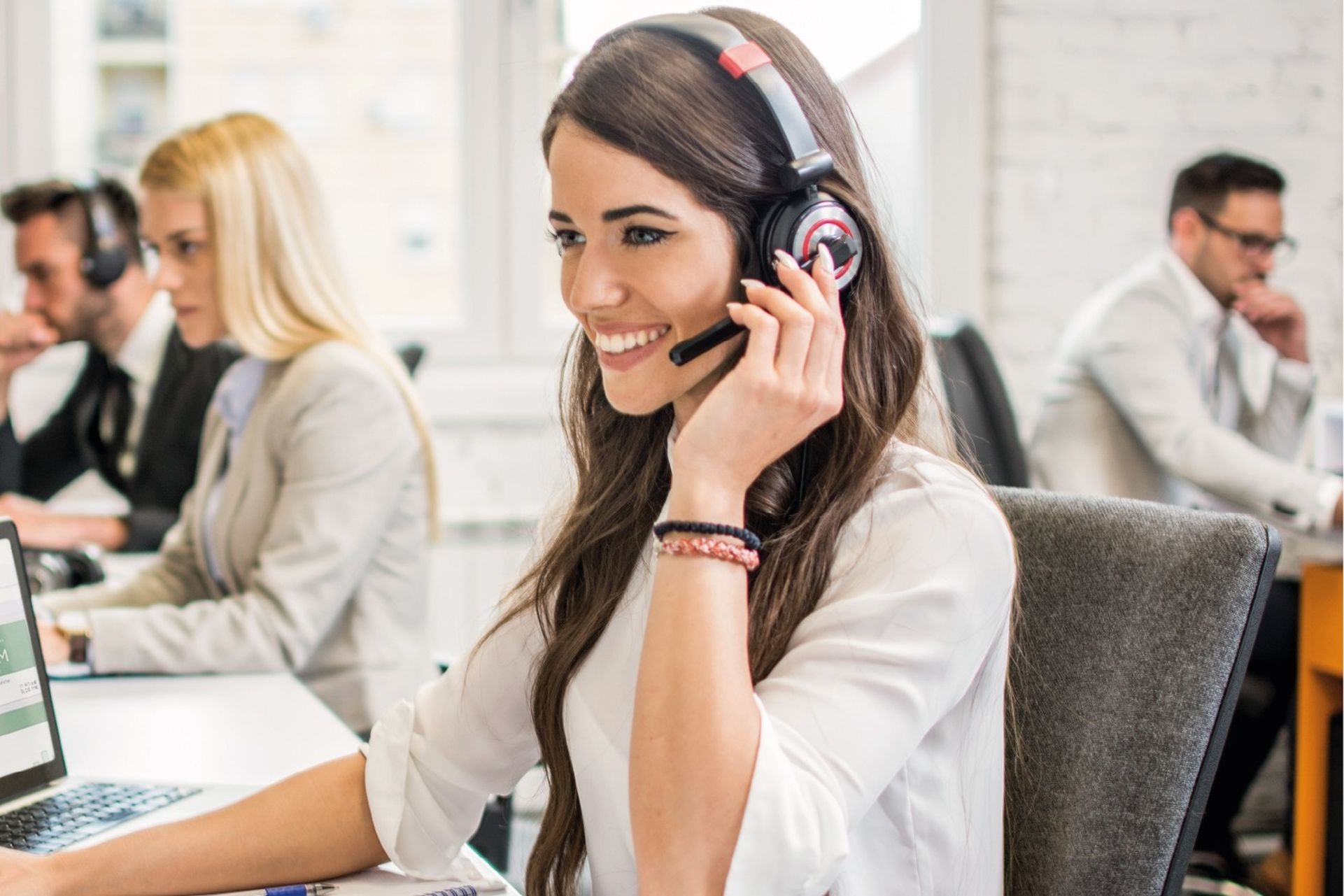 Frau mit Headset am Laptop