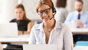 Frau mit Headset am Laptop