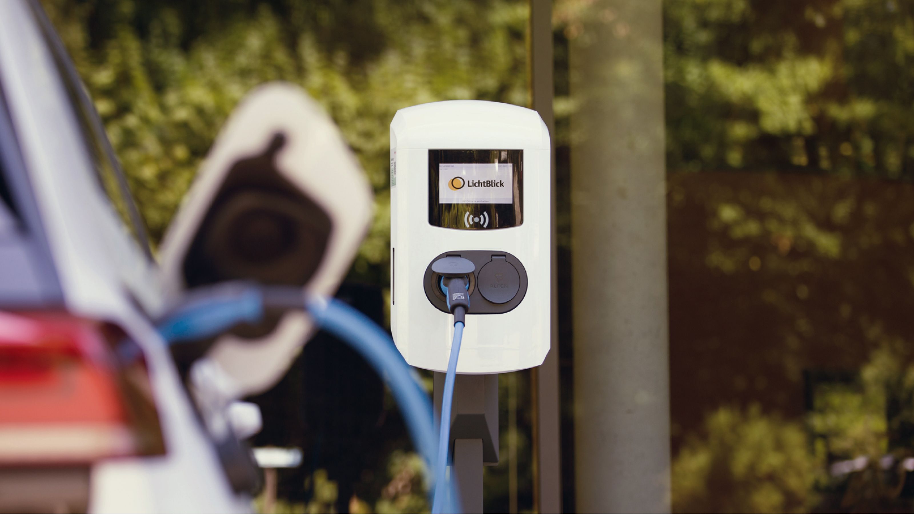 Ladesäule mit verschwommenem Auto im Vordergrund