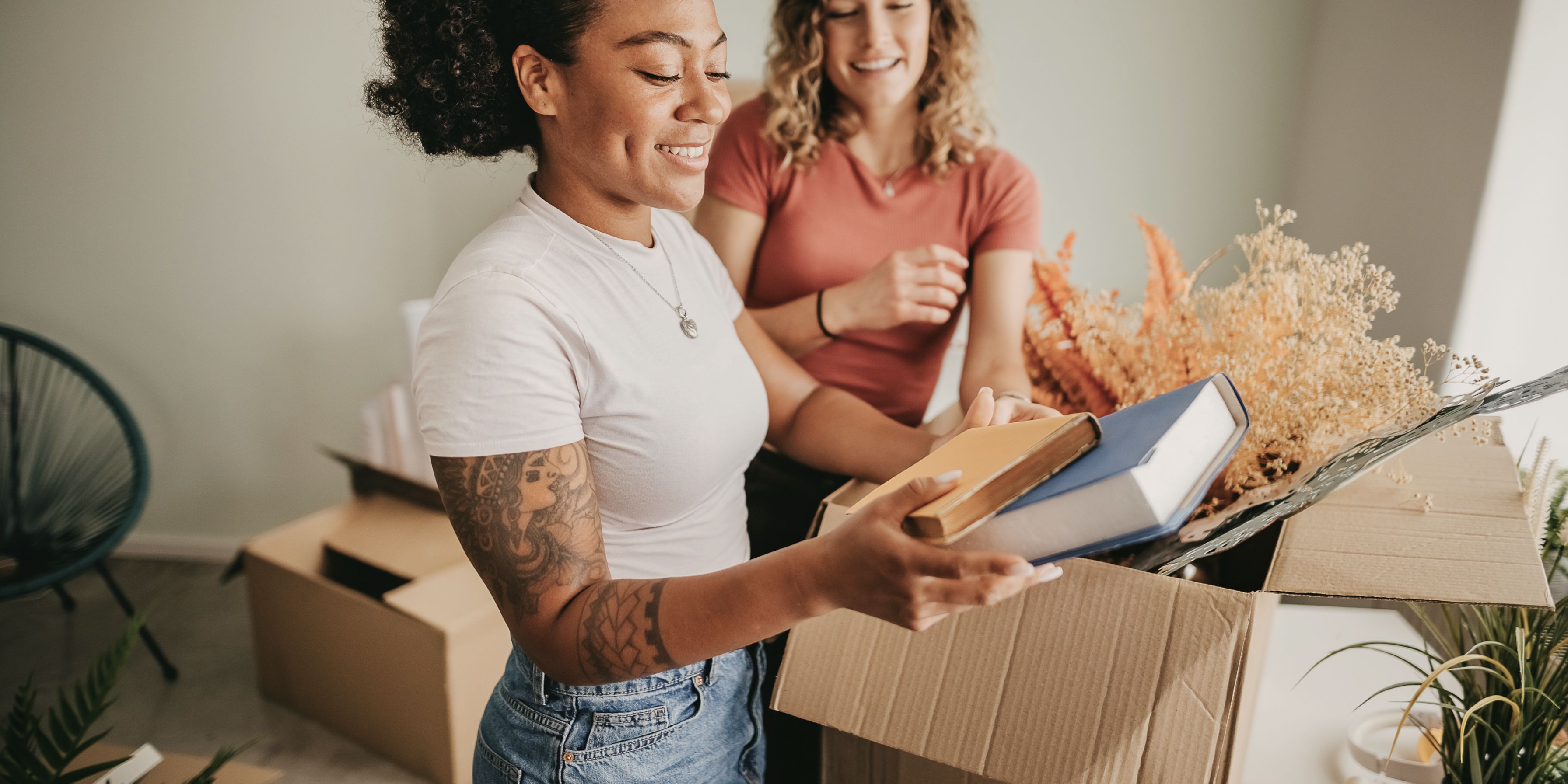 zwei Frauen beim Karton packen für den Umzug