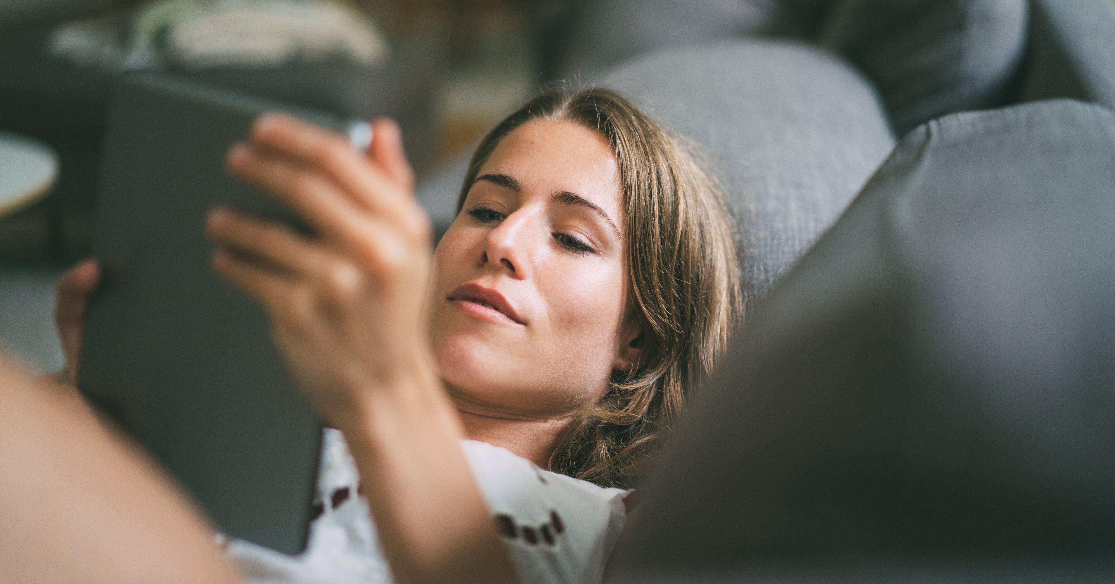 Frau mit Tablet auf Sofa