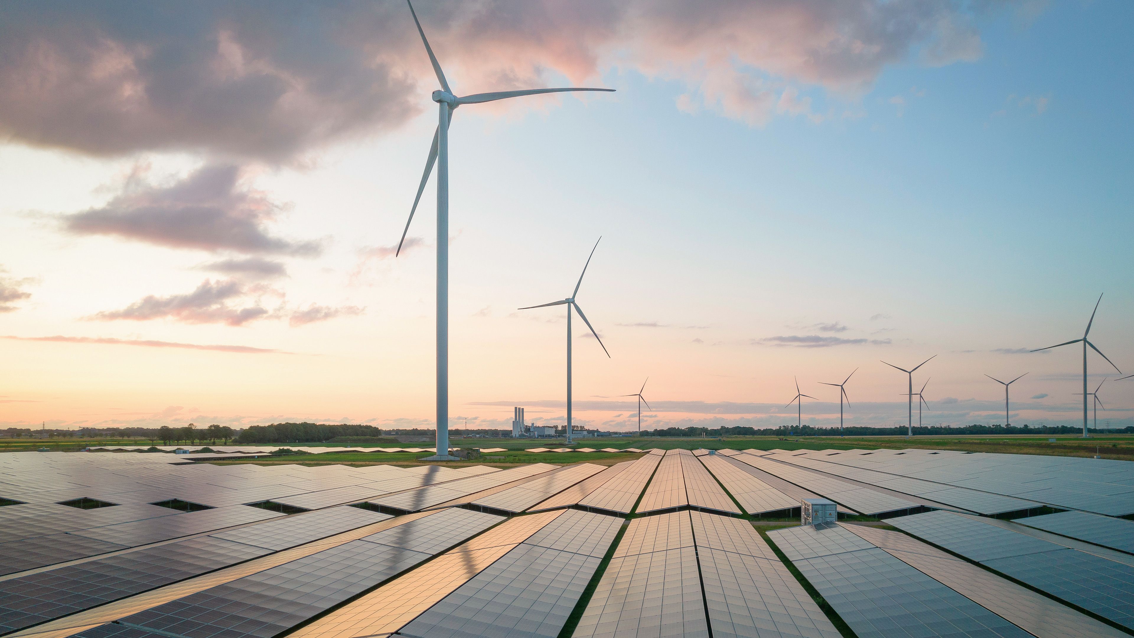 Solarpark im Abendlicht im Hintergrund WIndraeder