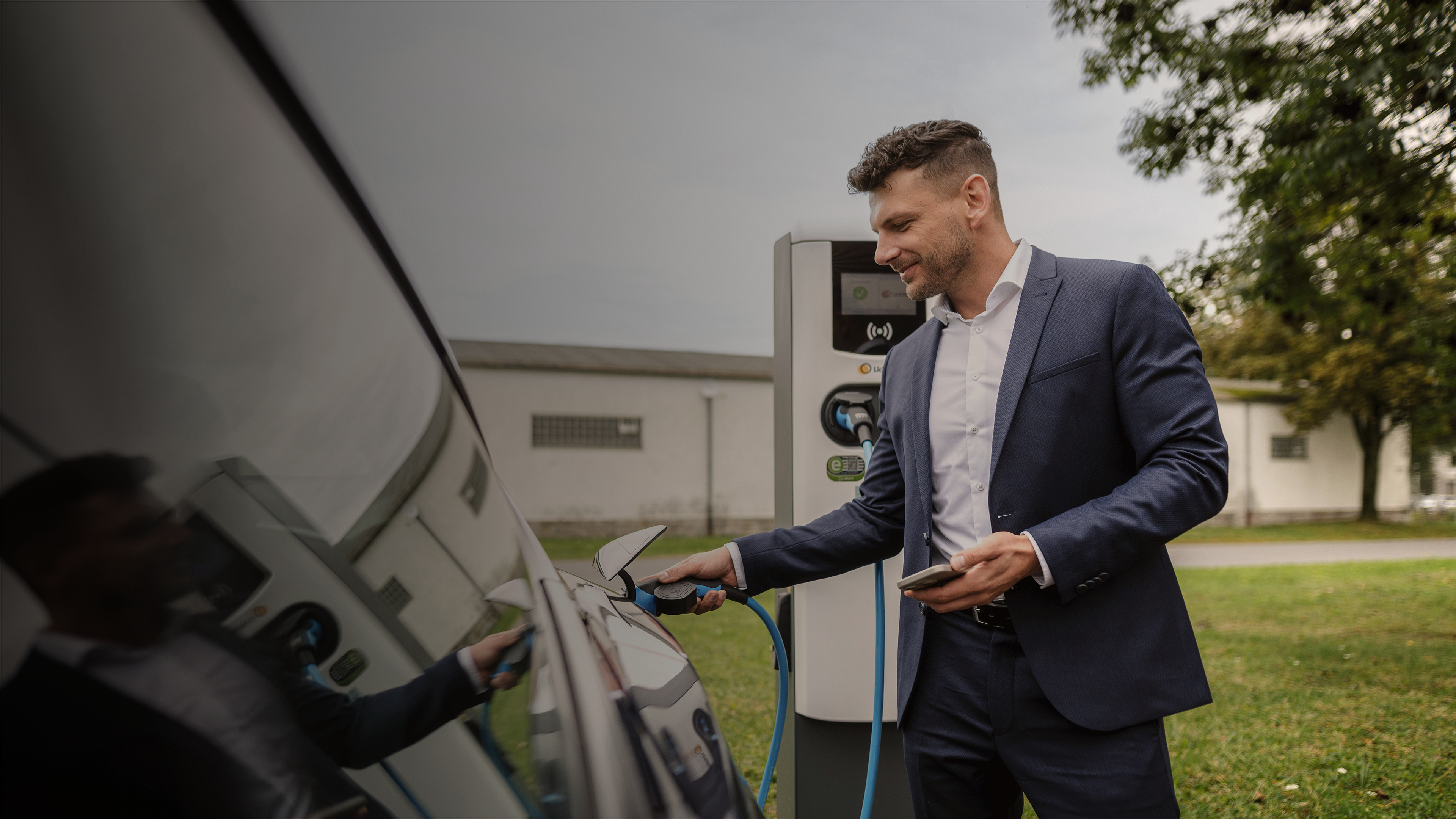 Mann lädt sein E-Auto auf