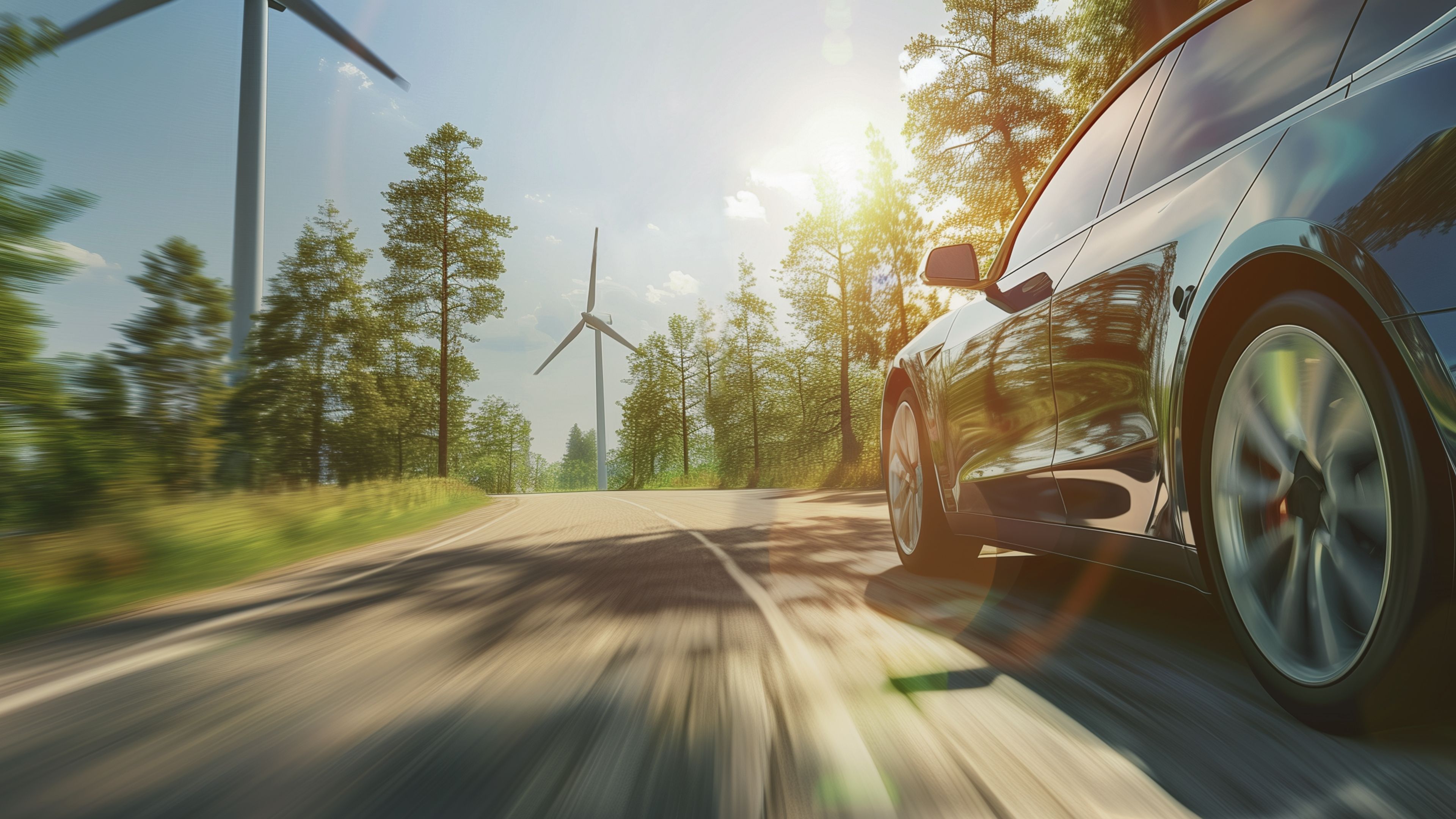 E-Auto fährt durch eine Landschaft an einem Windrad vorbei