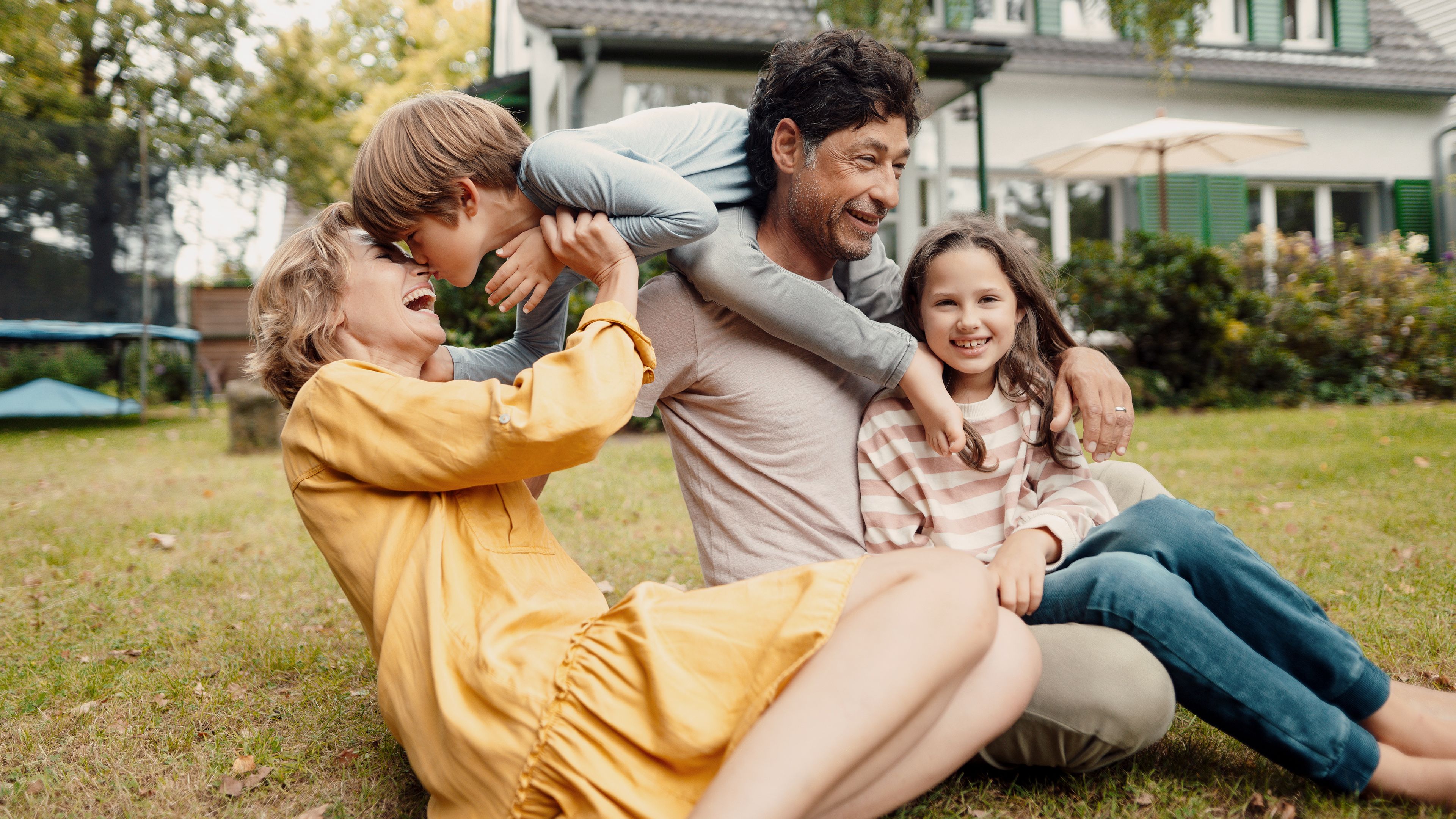 Familie im Garten vor dem Zuhause
