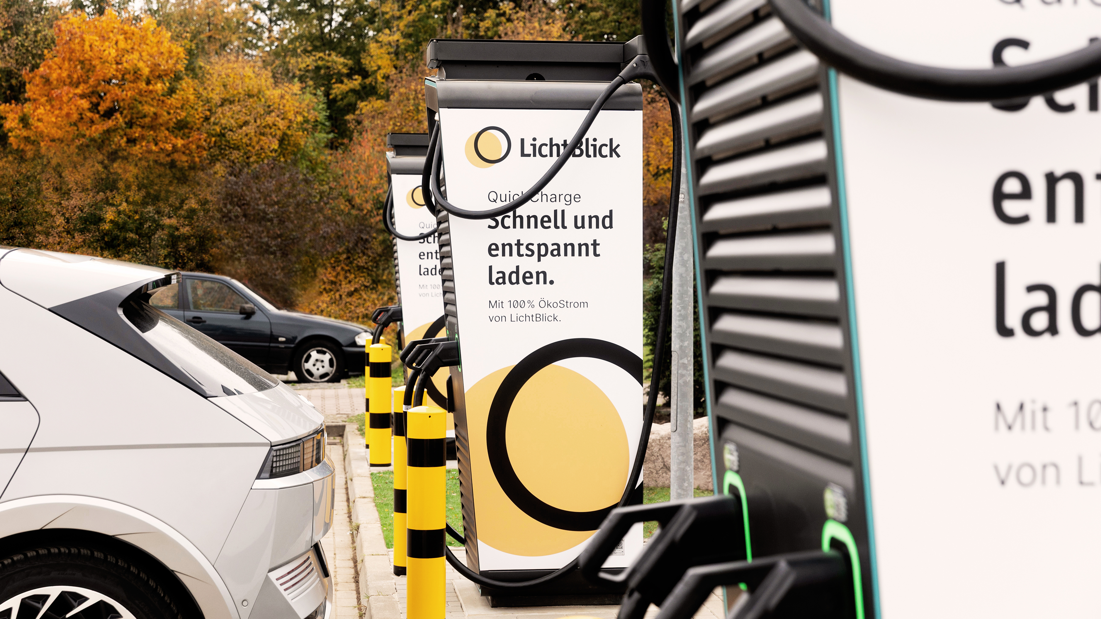 E-Auto lädt an Ladestation auf Parkplatz