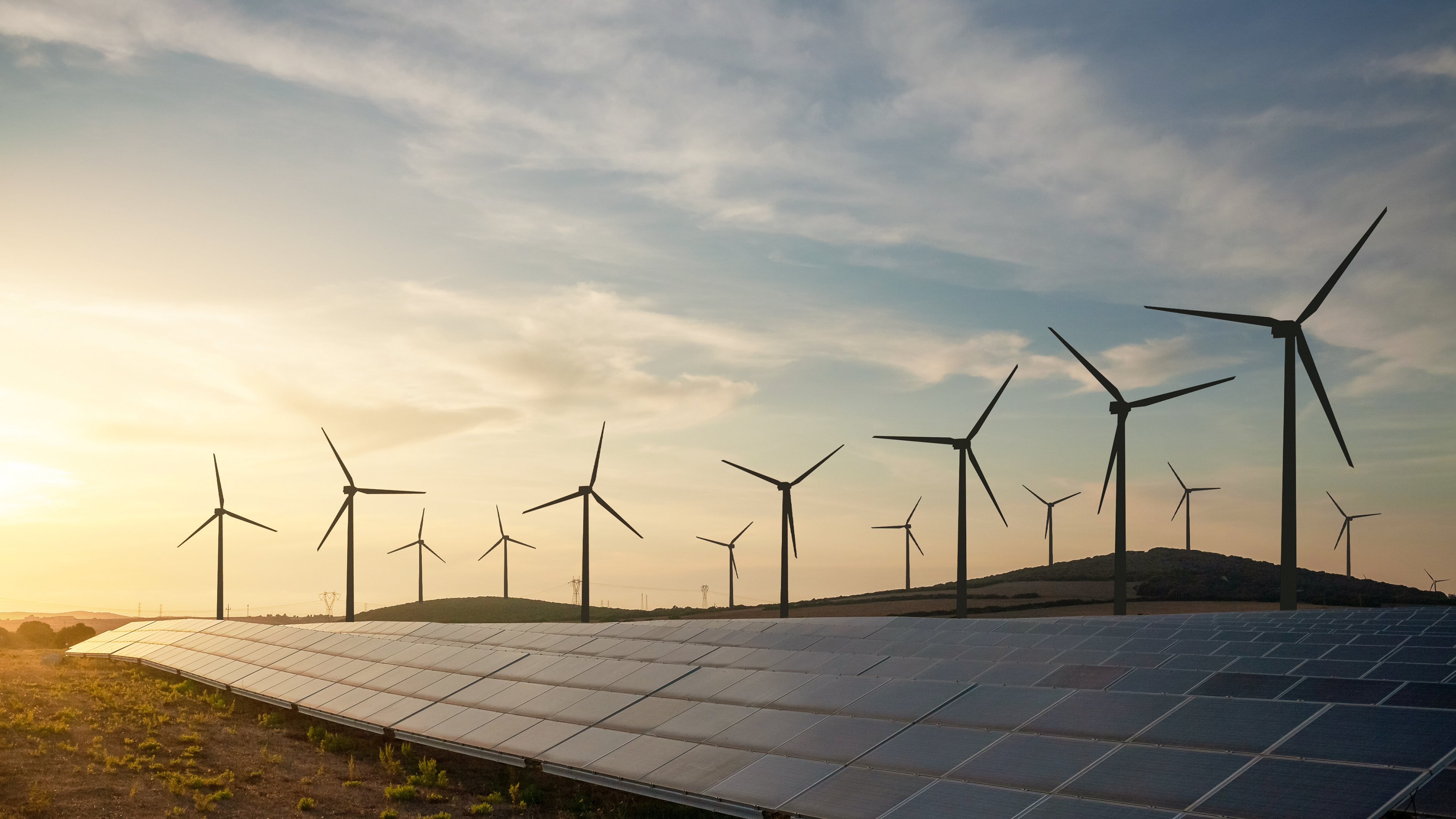 Solarpark im Abendlicht im Hintergrund Windraeder