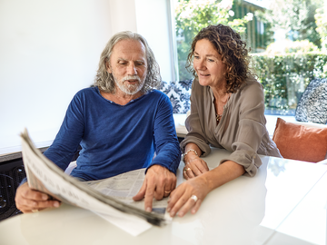 Zwei Frauen lesen ein Buch auf dem Sofa