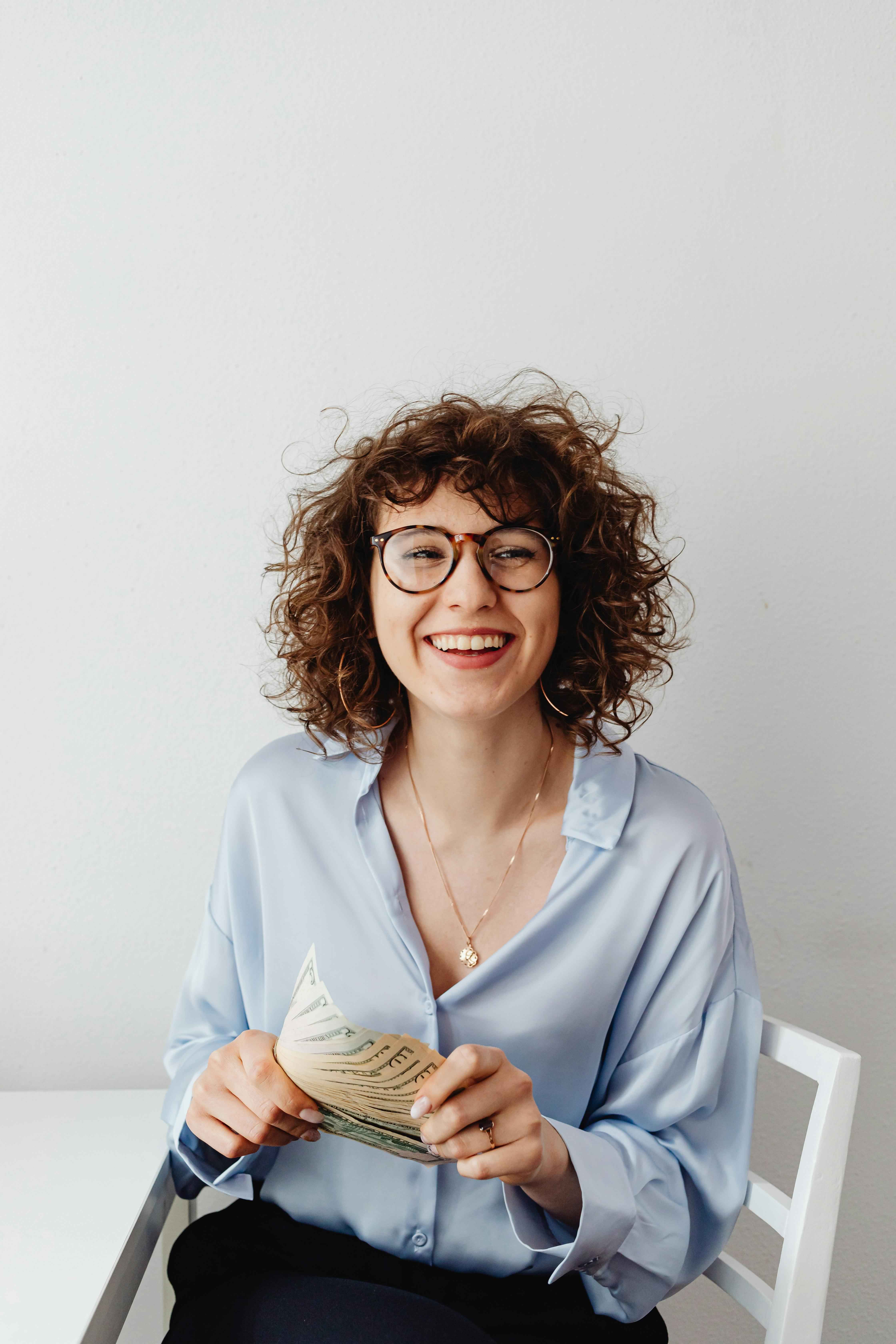 femme souriant avec une liasse de billets