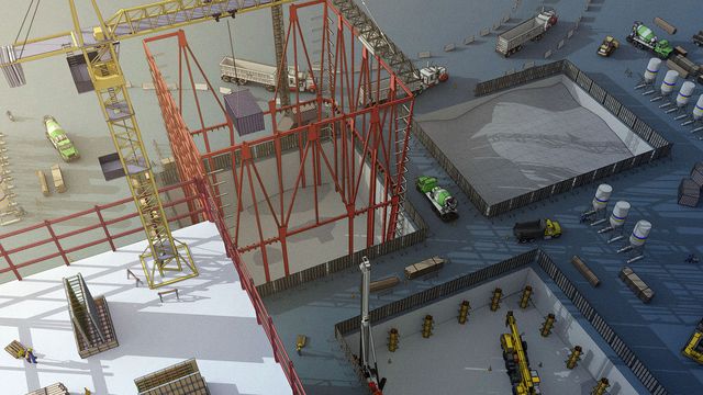 Aerial view of a construction site with cranes, red steel frames, concrete mixers, trucks, and silos arranged over a spacious, fenced area.