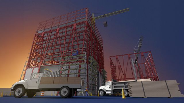 Construction site at sunset with cranes, two trucks, scaffolding, and workers wearing safety gear near partially built red steel structures.