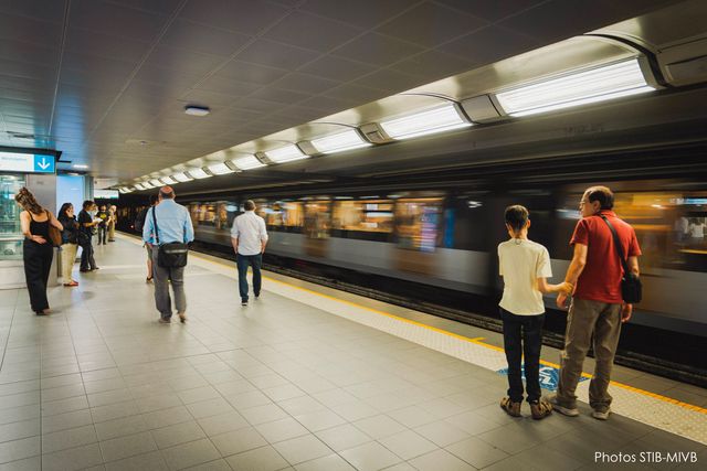Passengers wait on a STIB-MIVB metro platform in Brussels as a train arrives at the station.