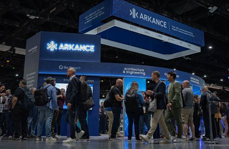 People gather at the Arkance booth during a convention, with displays on architecture, engineering, and digital transformation.