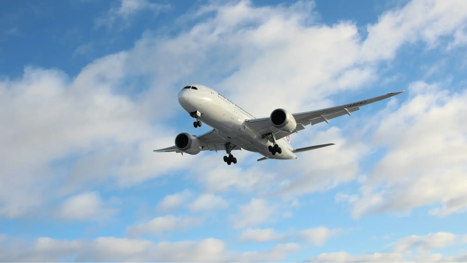 A passenger jet taking off against a cloudy blue sky