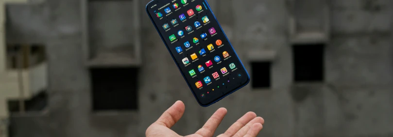 A hand tossing a smartphone into the air