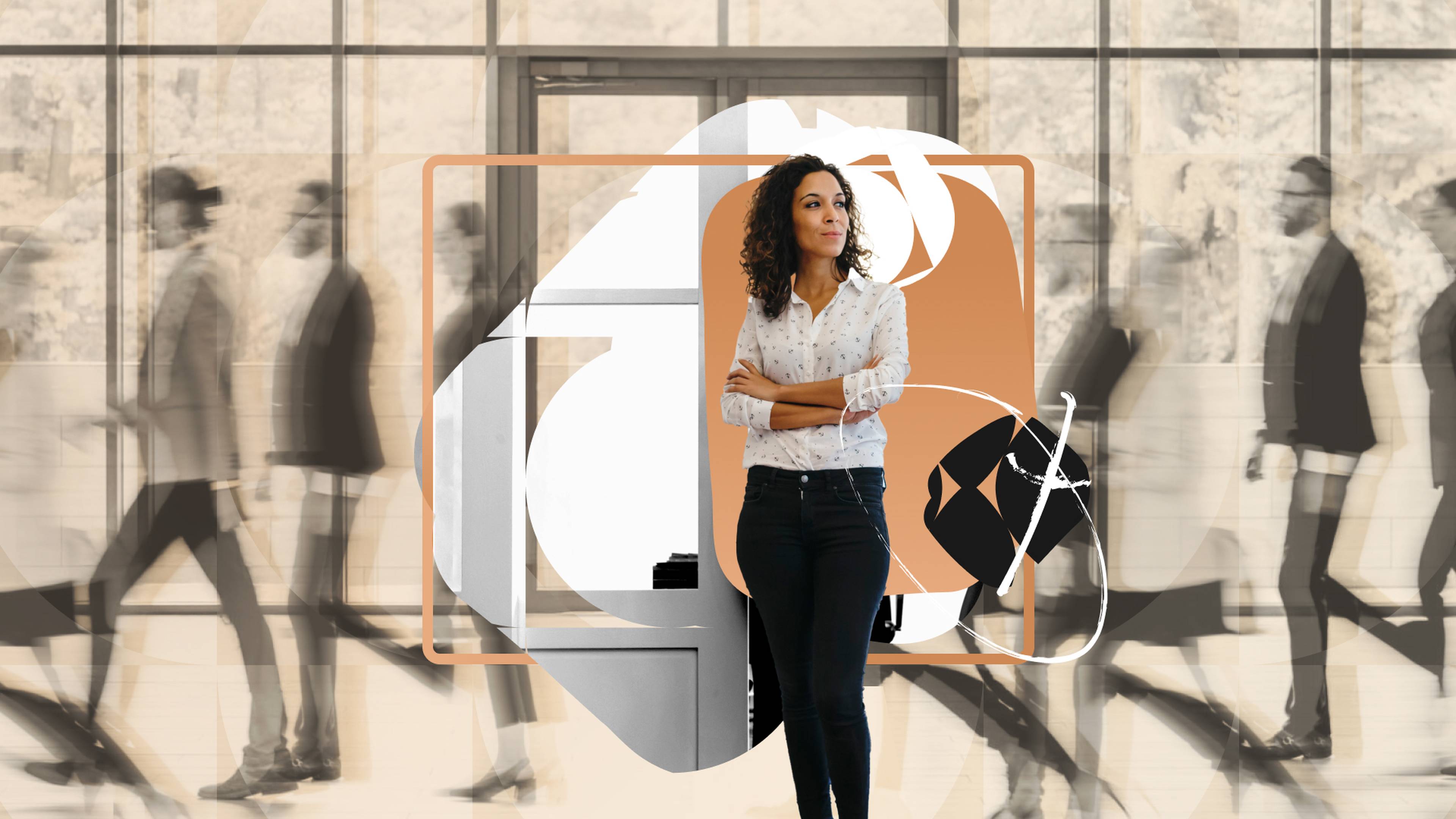 A leader stands in a work place pausing amidst busyness of people behind